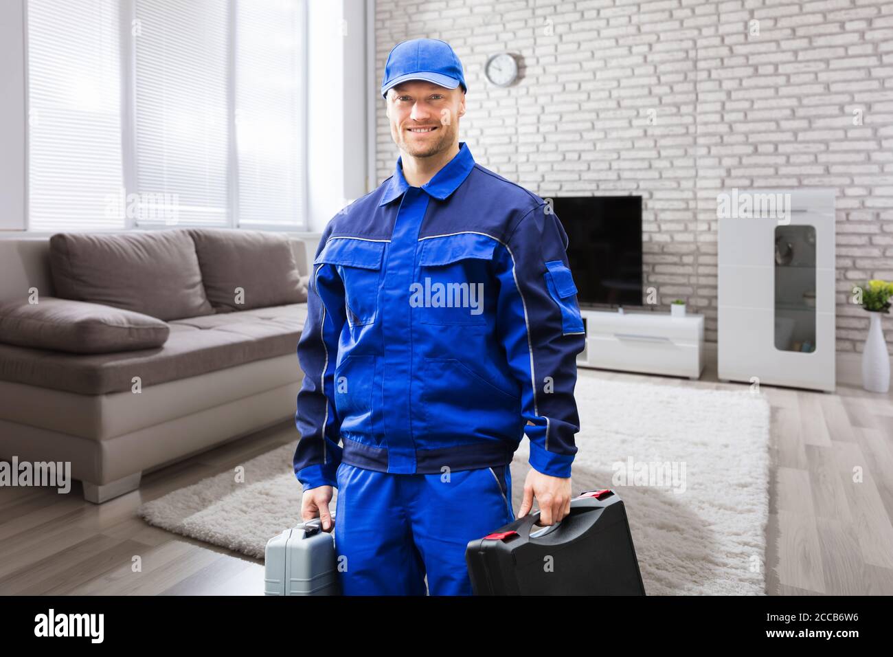 Sorridente uomo tecnico addetto alla riparazione ritratto a casa Foto Stock