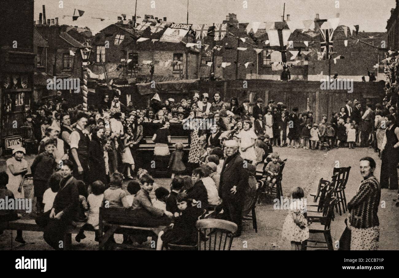 I londinesi organizzano una festa di strada nel 1935, in celebrazione del Re Giorgio V e del Giubileo d'Argento della Regina Maria di 25 anni sul trono. Foto Stock