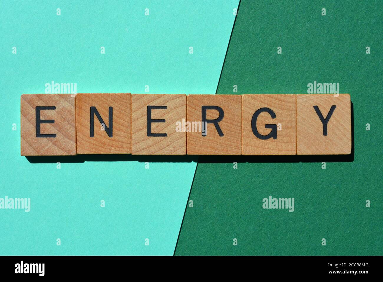 Energia, parola in lettere alfabetiche in legno isolate su sfondo verde e turchese Foto Stock