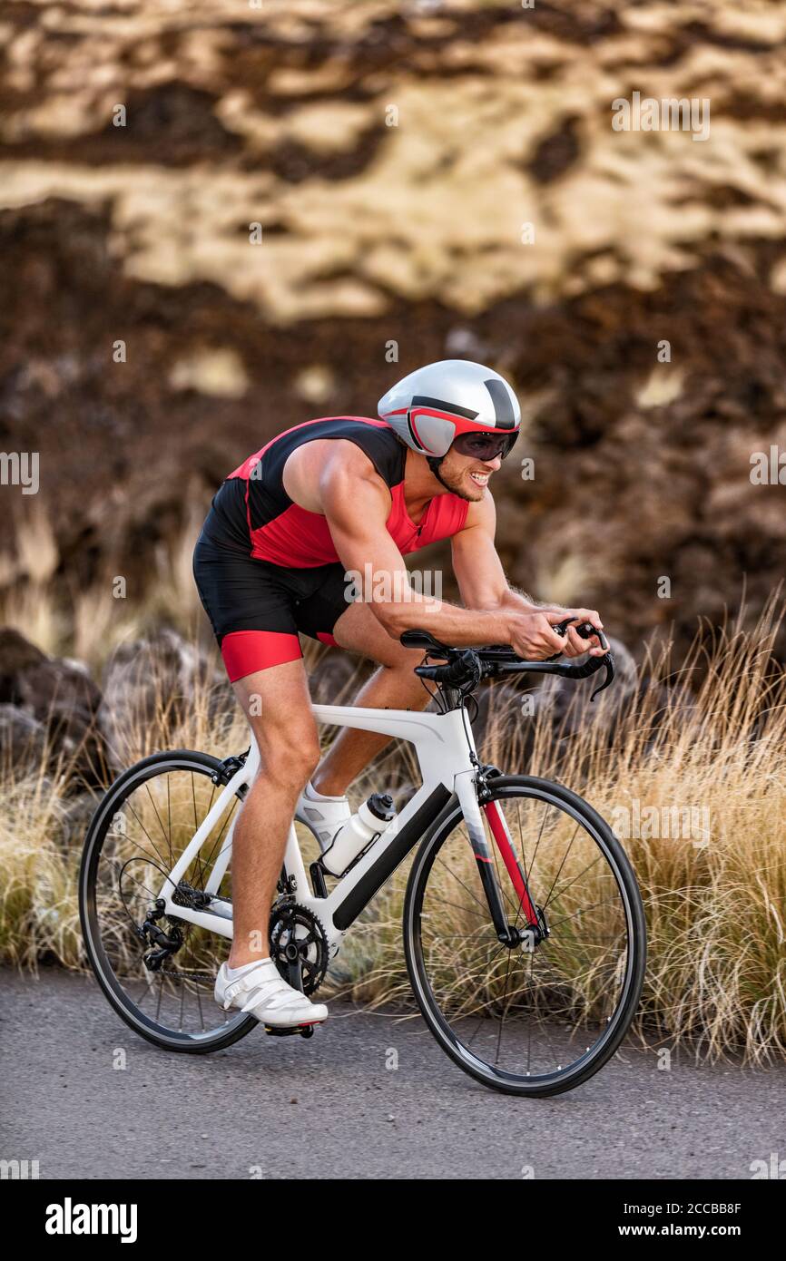 Triathlon professionista ciclista uomo ciclismo bici strada in tempo Casco di prova e tuta a a compressione in Hawaii paesaggio per Ironman Kailua-Kona Foto Stock