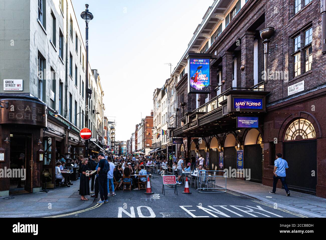 I clienti cenano all'aperto su una strada pedonale, Old Compton Street, Soho, Londra, Regno Unito. Foto Stock