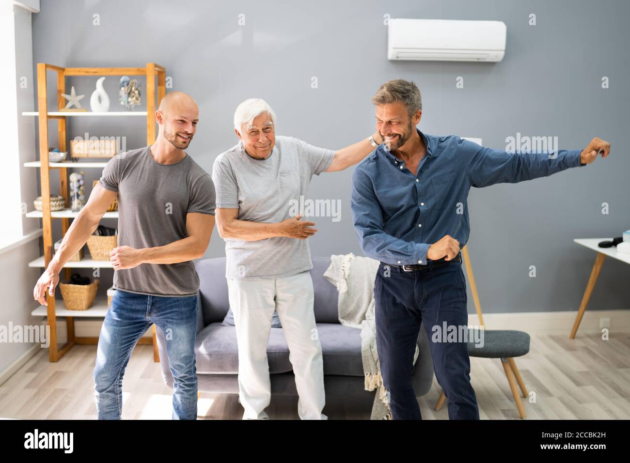 Tre generazione uomini che ballano ed esercitandosi con il nonno anziano Foto Stock