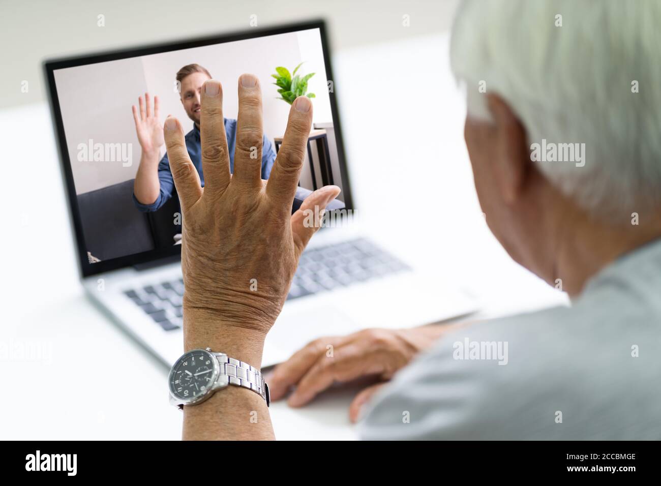 Senior Man Video Conferencing con suo figlio su laptop Foto Stock