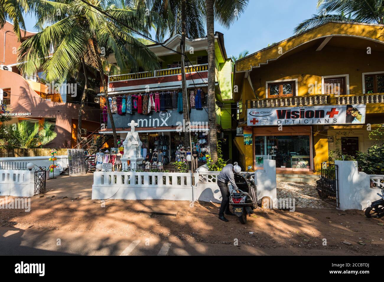 Candolim, Nord Goa, India - 23 novembre 2019: Vista di strada di Goa in giornata di sole con biciclette parcheggiate vicino negozi turistici e farmacia a Candolim, Nord G Foto Stock