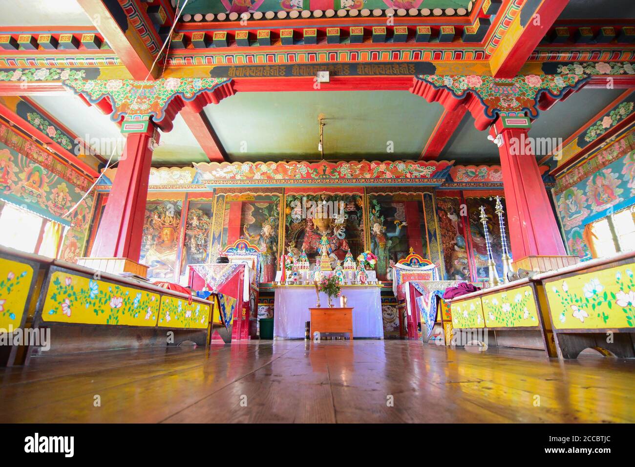 Rinchenpong, Sikkim, India - 17 ottobre 2016 : statue religiose del Buddismo che si riflettono su un terreno di legno nel monastero di Rinchenpong con tetto decorato. Foto Stock