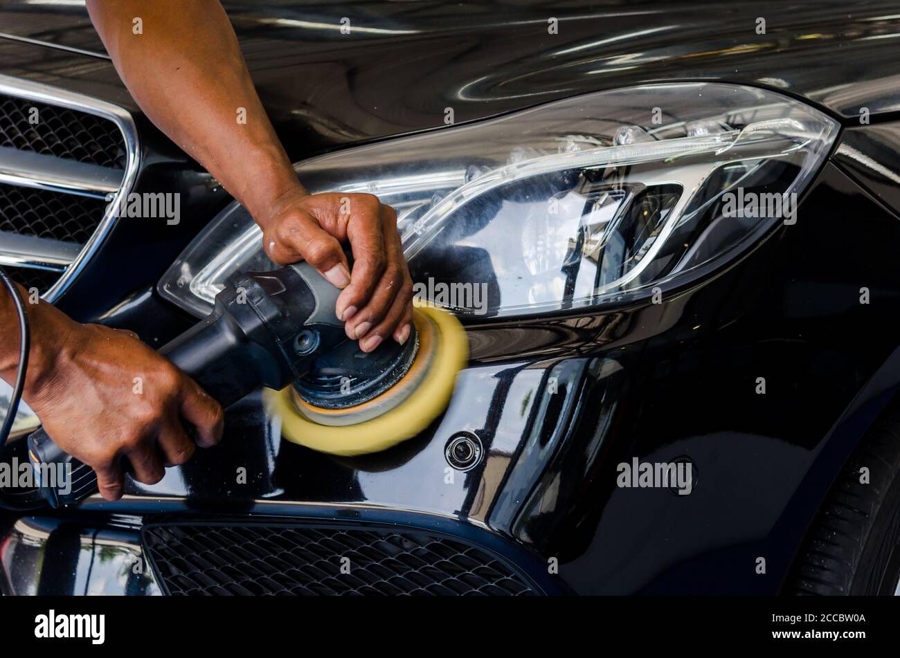 L'uomo mani tenendo l'attrezzo di lavoro polacco la vettura.Pulitura e lucidatura auto. Dettagli auto. Foto Stock