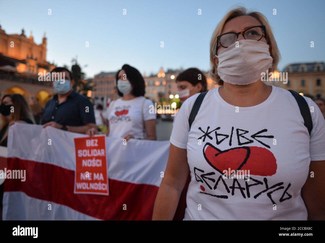 Cracovia, Polonia. 20 Agosto 2020. Durante la manifestazione, i manifestanti detengono una bandiera bielorussa bianca-rossa-bianca.dieci giorni dopo le controverse elezioni presidenziali bielorusse del 2020, i bielorussi che vivono a Cracovia e i locali protestano in solidarietà con il popolo bielorusso e contro il regime del leader bielorusso Alexander Lukashenko, Durante il rally è stata organizzata una lampada a candela nella Piazza del mercato di Cracovia accanto al monumento Adam Mickiewicz. Credit: SOPA Images Limited/Alamy Live News Foto Stock