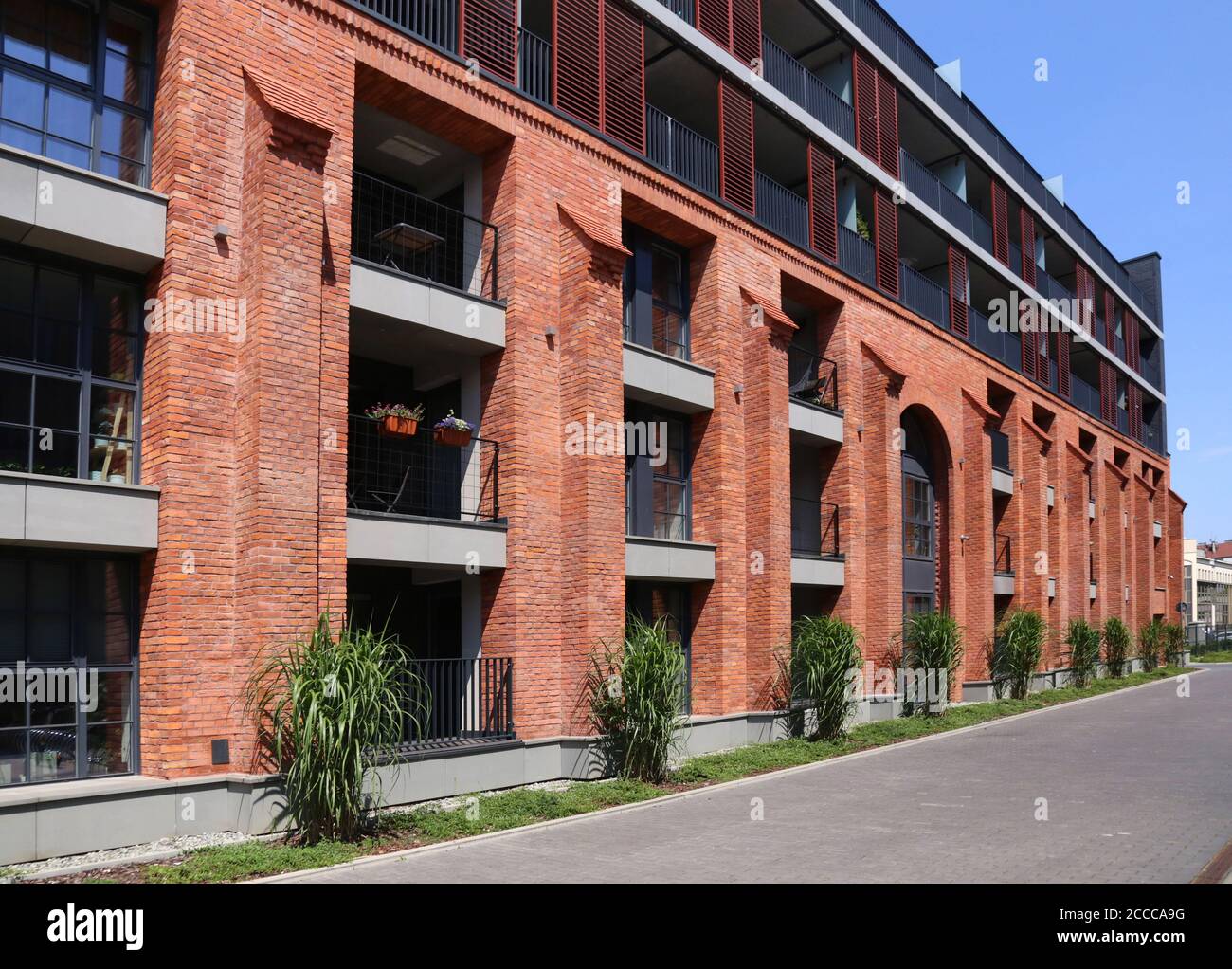 Cracovia. Cracovia. Polonia. Vecchio edificio di fabbrica trasformato in casa di appartamenti. Facciata in mattoni rossi. Foto Stock