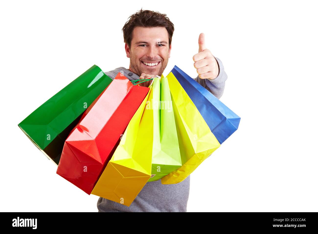 L'uomo con un sacco di borse colorate tiene il pollice su Foto Stock