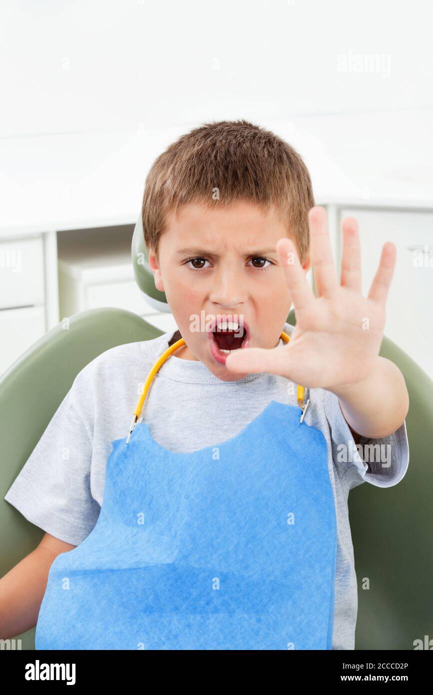 Il bambino ansioso al dentista tiene fuori la sua mano Foto Stock