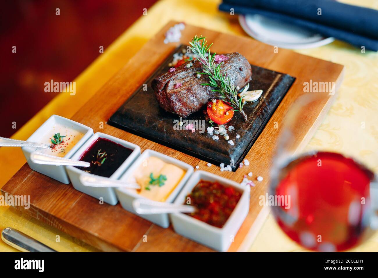Il cibo del ristorante. Carne di maiale alla griglia il piatto con verdure fresche. Medaglioni con erbe e spezie. Foto Stock