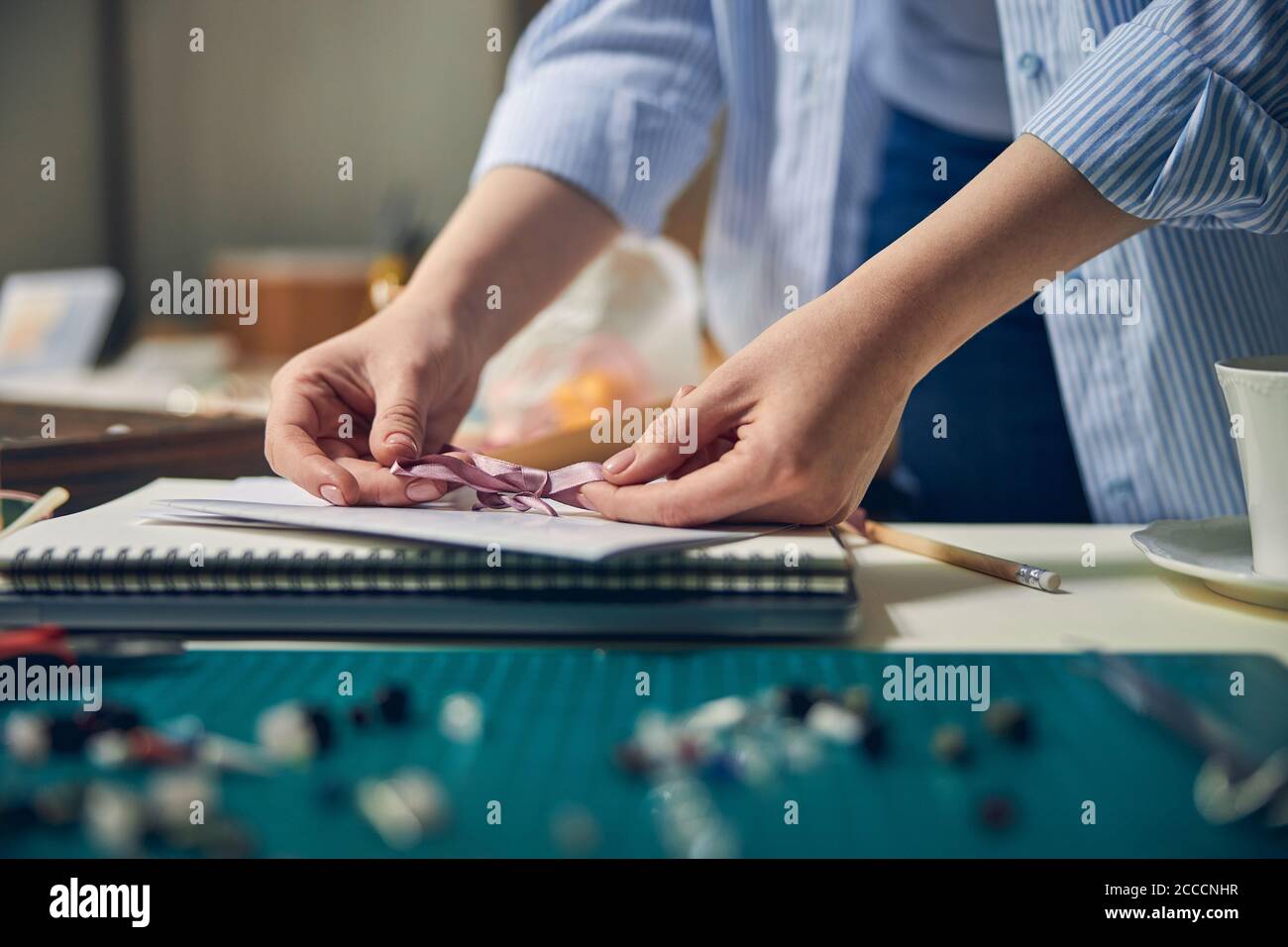 Femmina caucasica che fa un fiocco su carta certificato Foto Stock