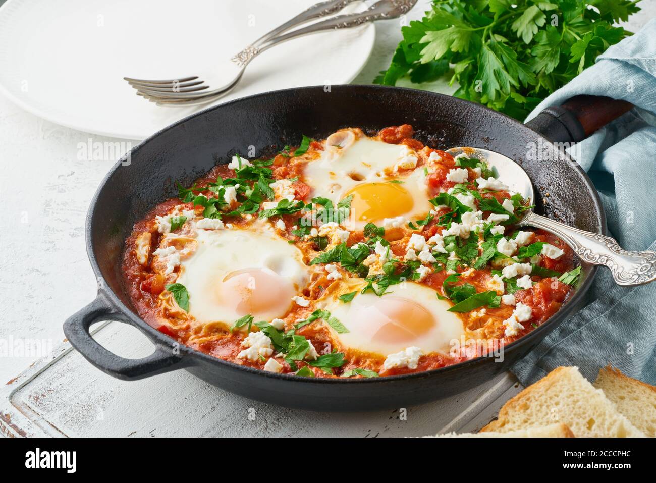 Shakshouka, uova in camicia in salsa di pomodori, olio d'oliva. Cucina mediterranea. Foto Stock