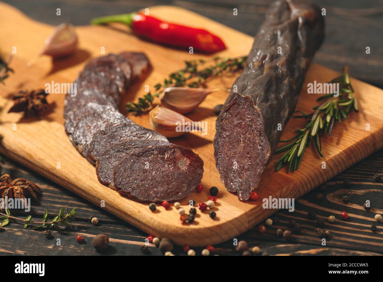 Caccia salsicce salsicce su uno sfondo scuro. Foto Stock