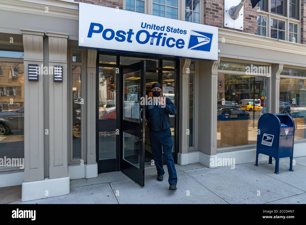 NEW YORK, NY - AGOSTO 17: Un uomo esce da un ufficio postale USPS (United States Postal Service) a Long Island City il 17 agosto 2020 a Queens Borough di NE Foto Stock