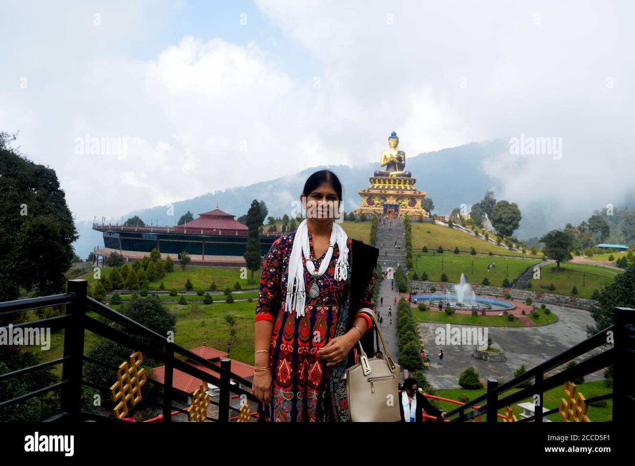 Una Signora Indiana in posa per una foto di fronte alla Statua del Buddha del Parco Ravangla di Sikkim, messa a fuoco selettiva Foto Stock