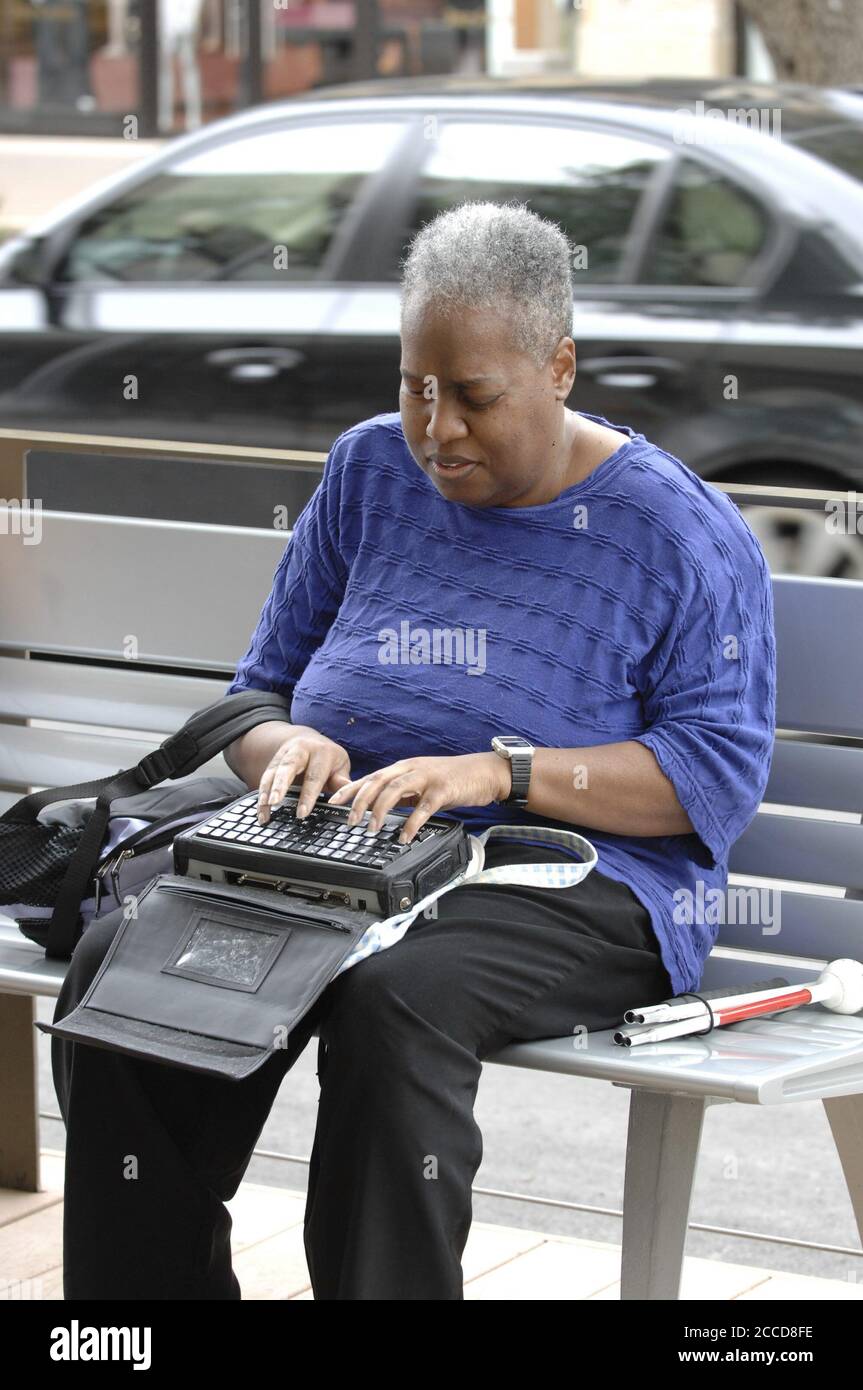 Austin, TX USA, 23 aprile 2007: Un acquirente afroamericano che si affina alla sua macchina 'BrailleNote', simile a un PDA (Personal Digital Assistant) per non vedenti, in un centro commerciale di lusso ad Austin. ©Bob Daemmrich Foto Stock
