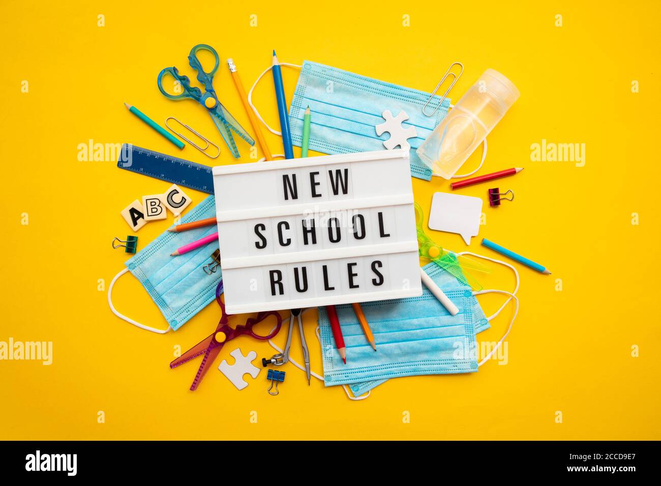 Nuovo messaggio di regole della scuola con attrezzature scolastiche e maschere di covid Foto Stock