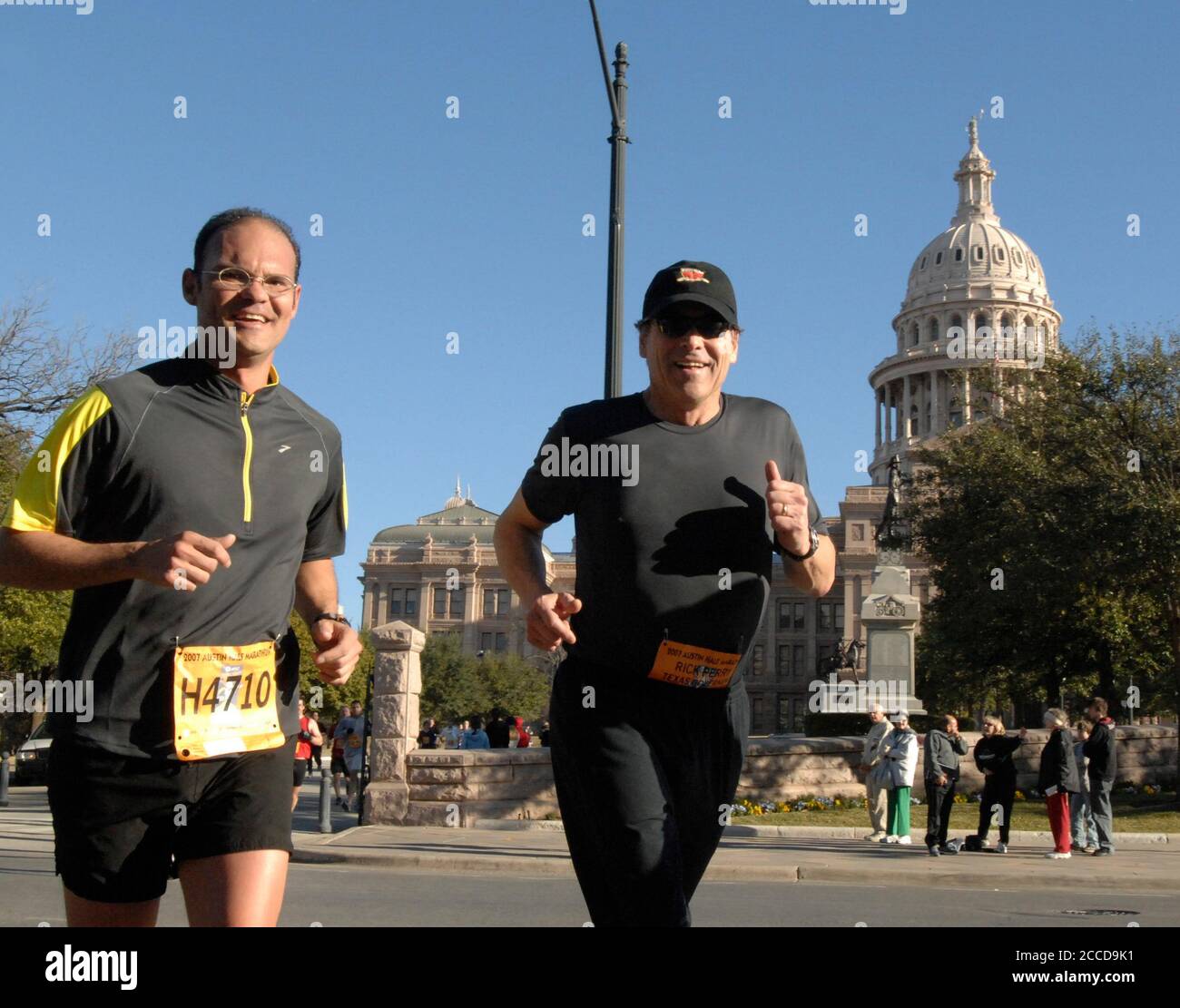 Austin, TX 18 febbraio 2007: Il governatore del Texas Rick Perry (r) passa davanti al Campidoglio con il guardiano di sicurezza Chris Brannen (l) verso il traguardo della mezza maratona domenicale alla gara di 26.2 miglia della Maratona di Austin. La gara è la quindicesima maratona più grande degli Stati Uniti. ©Bob Daemmrich Foto Stock