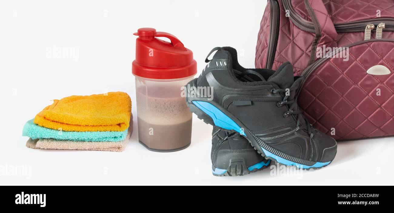 Borsa sportiva, sneakers, asciugamani e shaker con proteine del siero di latte, concetto di stile di vita fitness Foto Stock