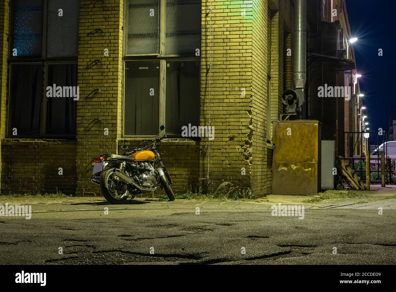 Una motocicletta di notte, una motocicletta si trova sotto una motocicletta vintage, un incrociatore e una luce di strada Foto Stock