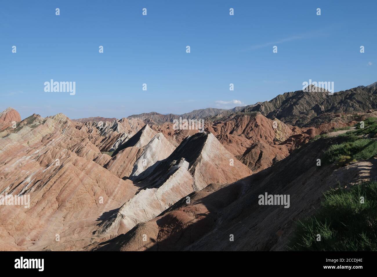 Angolo alto di molte colline Danxia Landform colorate in giornata di sole. Grandangolo. Foto Stock