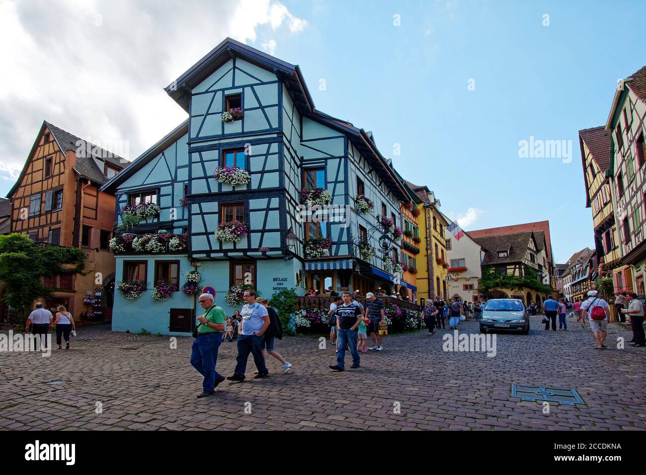 Scena stradale; edifici della città vecchia; a graticcio, ciottoli, 15-18 secoli; fiori, persone, villaggio fortificato; Alsazia; Europa, Riquewihr; Francia Foto Stock