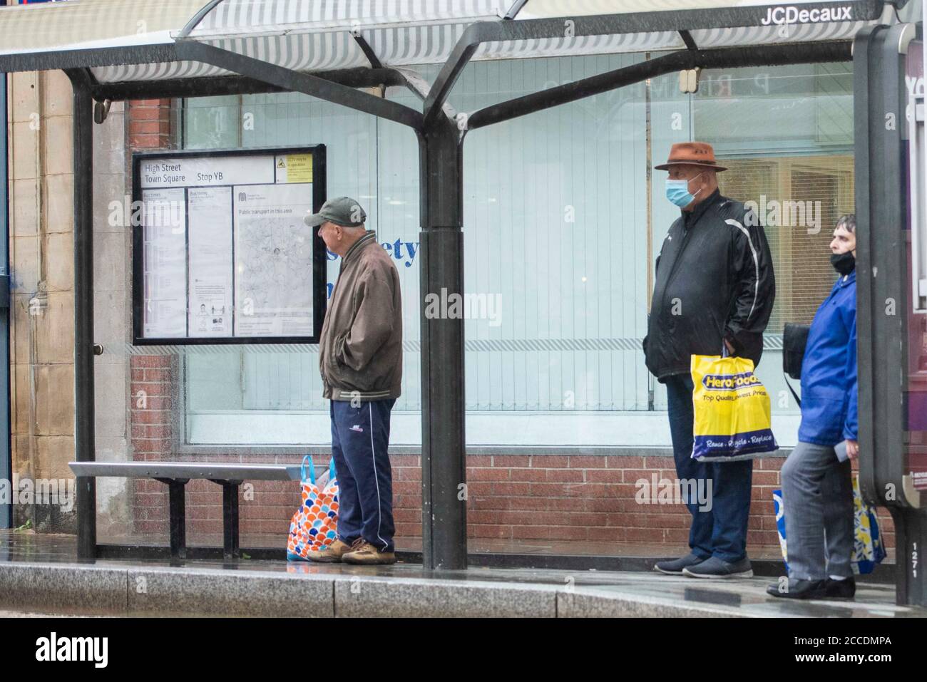 Bagnati e cupi iniziano la giornata per i membri del pubblico nel centro di Oldham, che si trova sul bordo della serratura. Foto Stock
