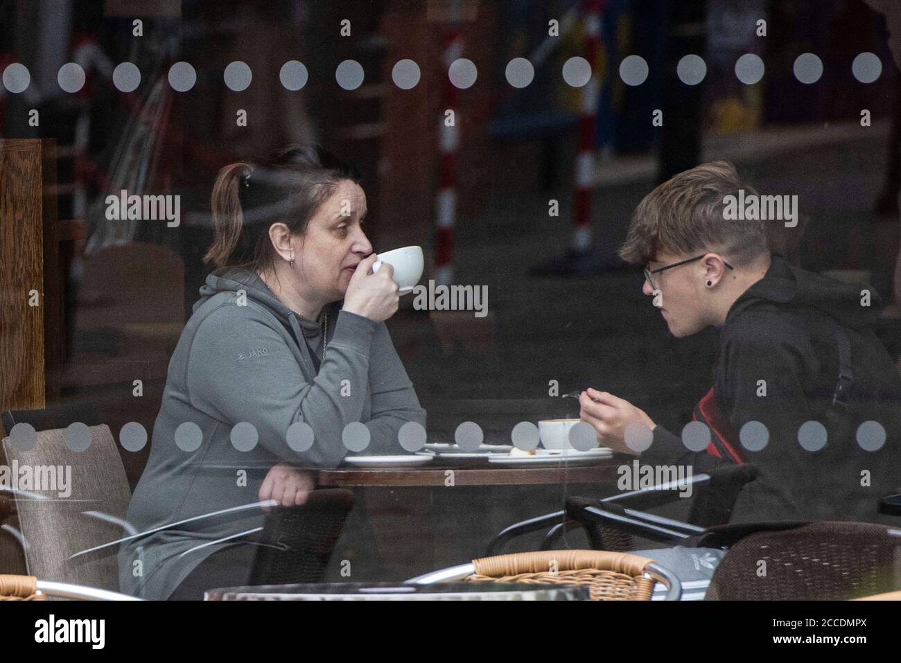 Bagnati e cupi iniziano la giornata per i membri del pubblico nel centro di Oldham, che si trova sul bordo della serratura. Foto Stock