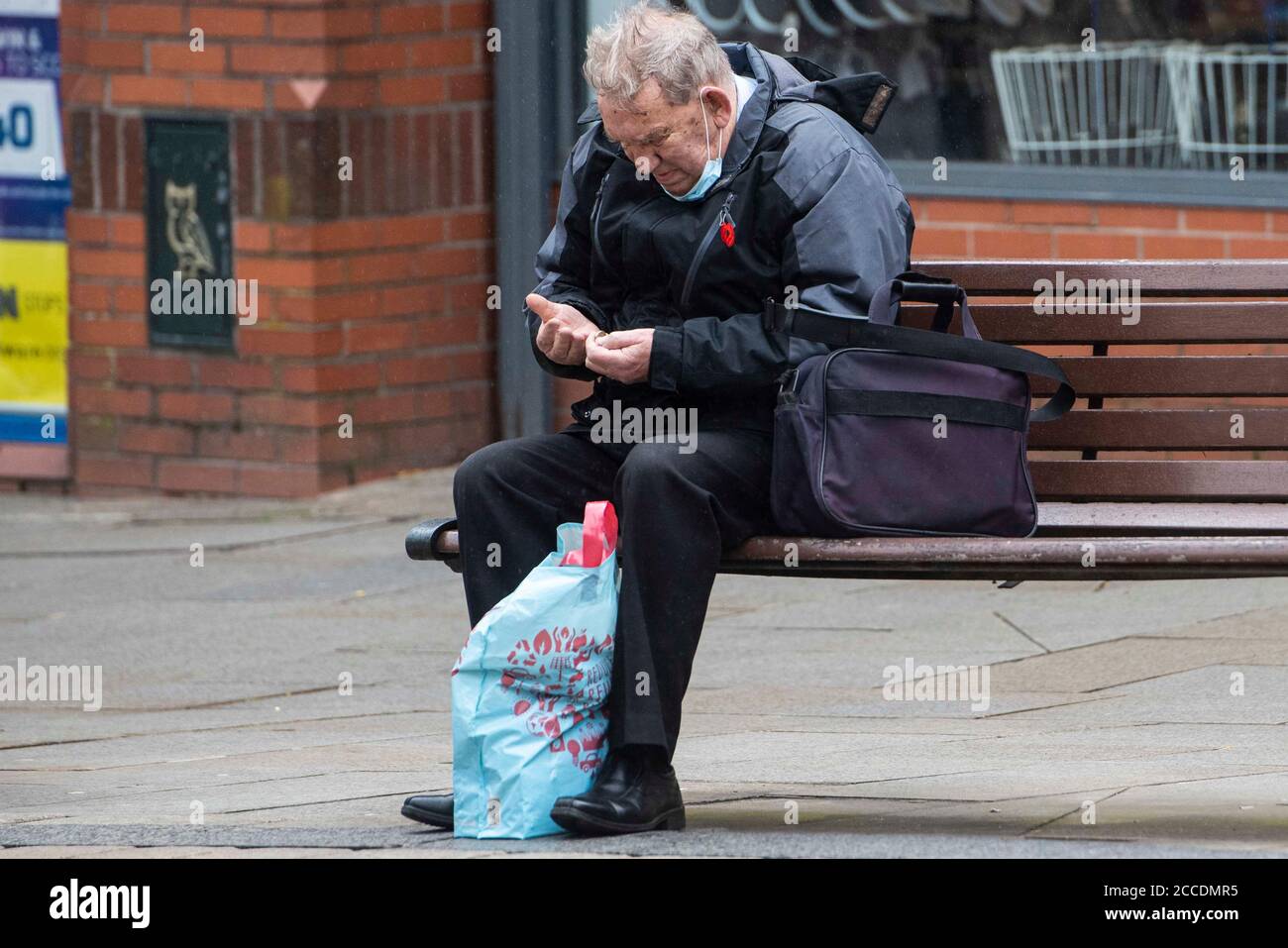 Bagnati e cupi iniziano la giornata per i membri del pubblico nel centro di Oldham, che si trova sul bordo della serratura. Foto Stock
