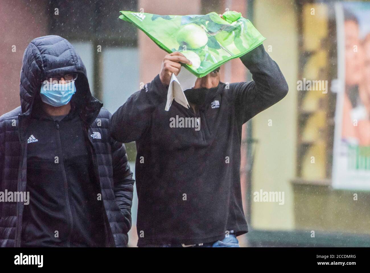 Bagnati e cupi iniziano la giornata per i membri del pubblico nel centro di Oldham, che si trova sul bordo della serratura. Foto Stock