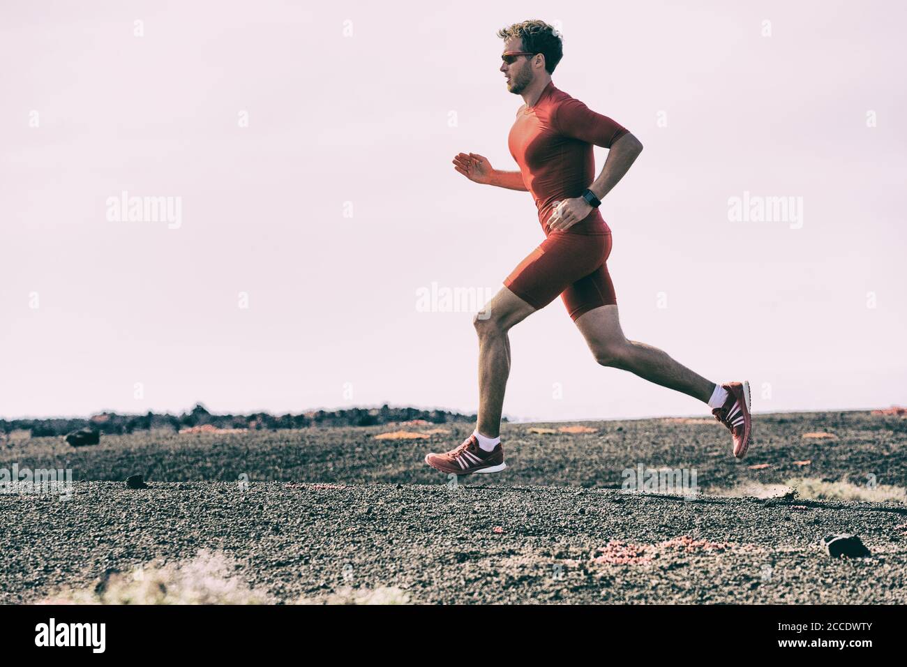 L'atleta sportivo si allena all'aperto facendo allenamento cardio Su pista fuori - Tryathlon runner man in corsa gara maratona in estate Foto Stock