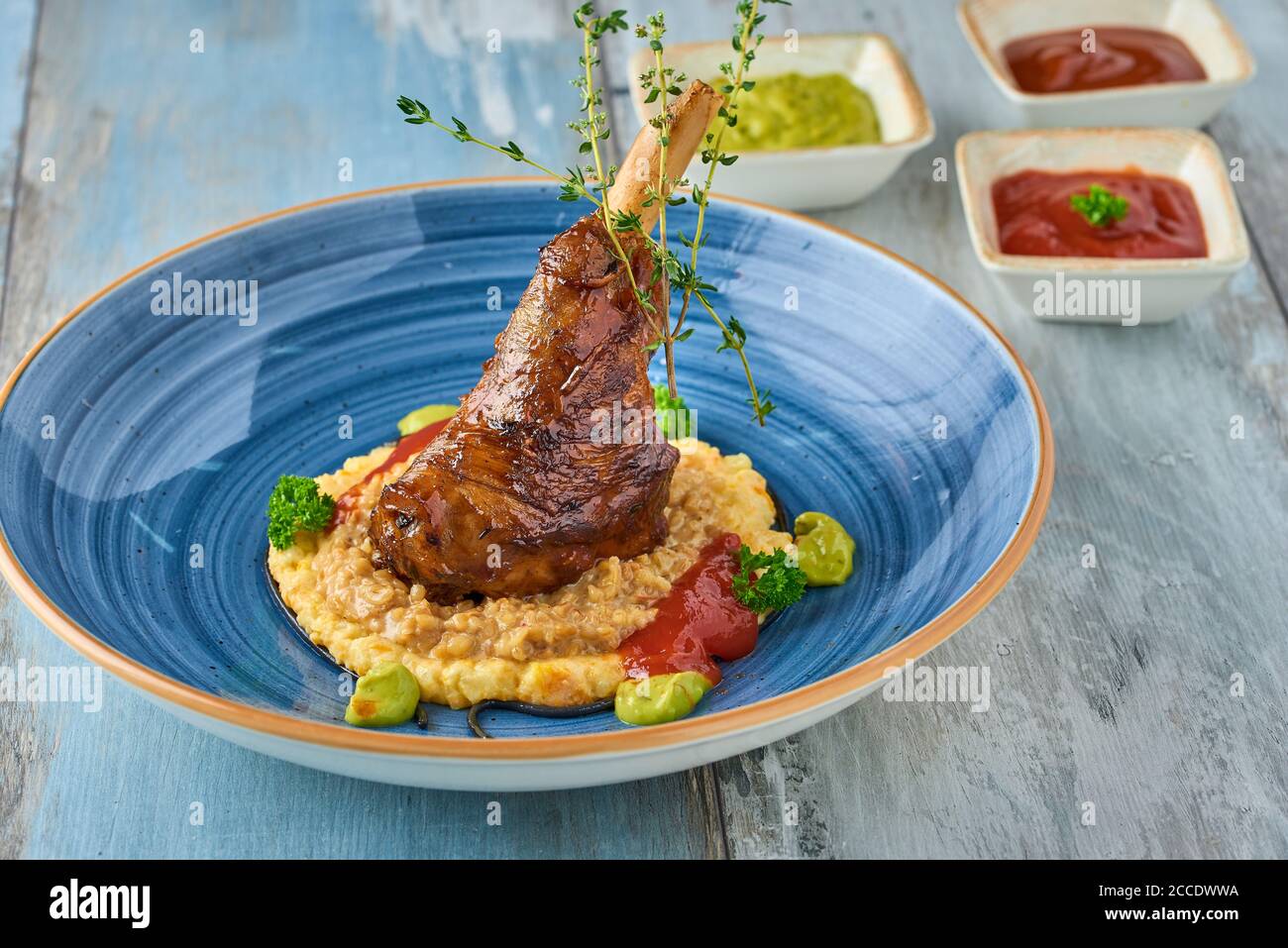 Gambo di agnello brasato sul purè di patate su tavola di legno Foto Stock