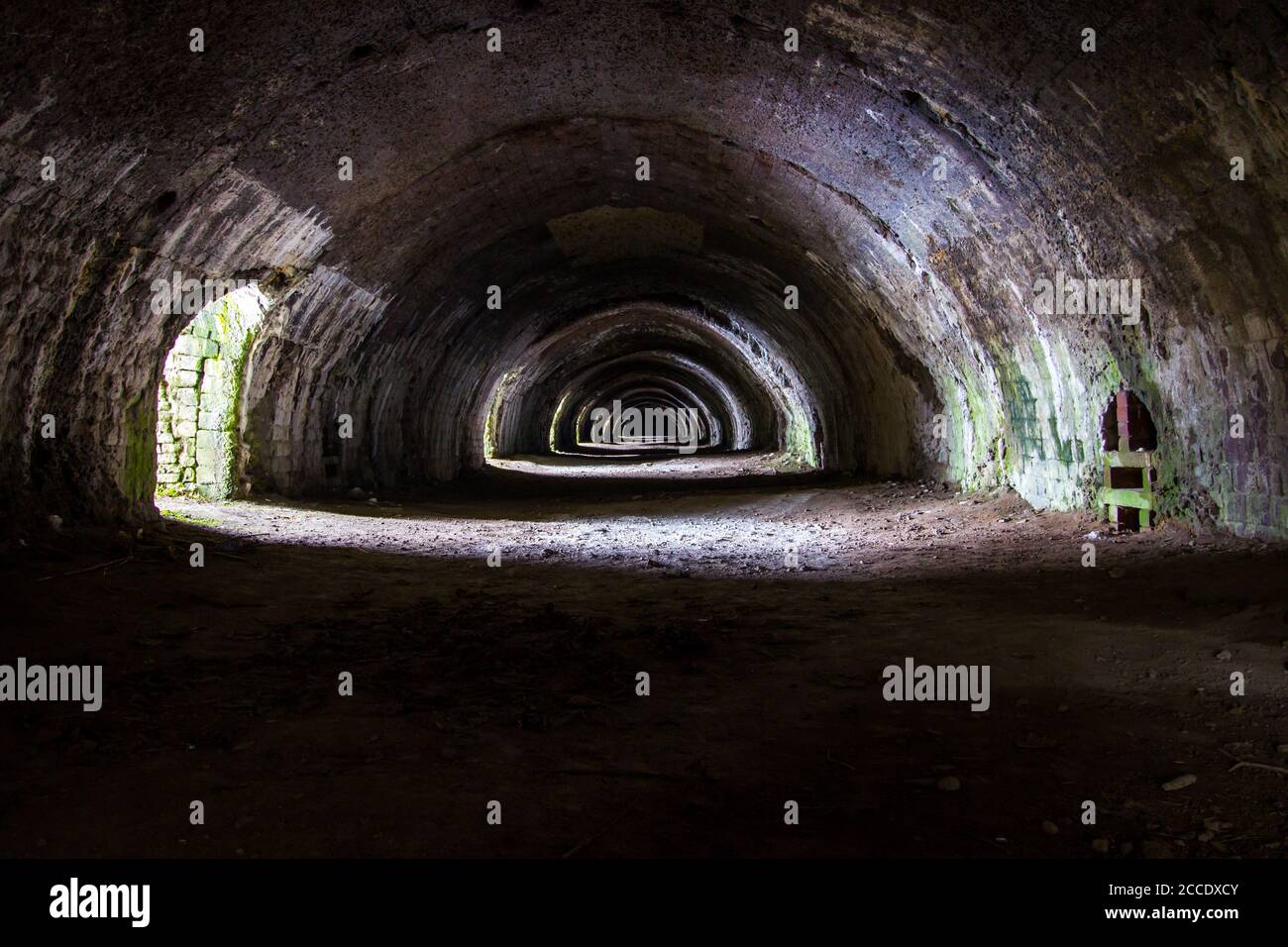 Langcliffe forno di lime in Settle, Yorkshire. Vecchio tunnel in pietra scura con archi e luce interessante Foto Stock