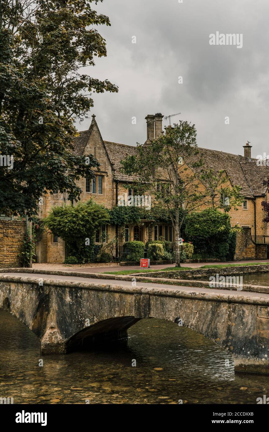Bourton-on-the-Water, Regno Unito - 10 luglio 2020: Piccolo ponte in pietra sul fiume Windrush a Bourton-on-the-Water, un famoso villaggio nelle Cotswolds rurali Foto Stock