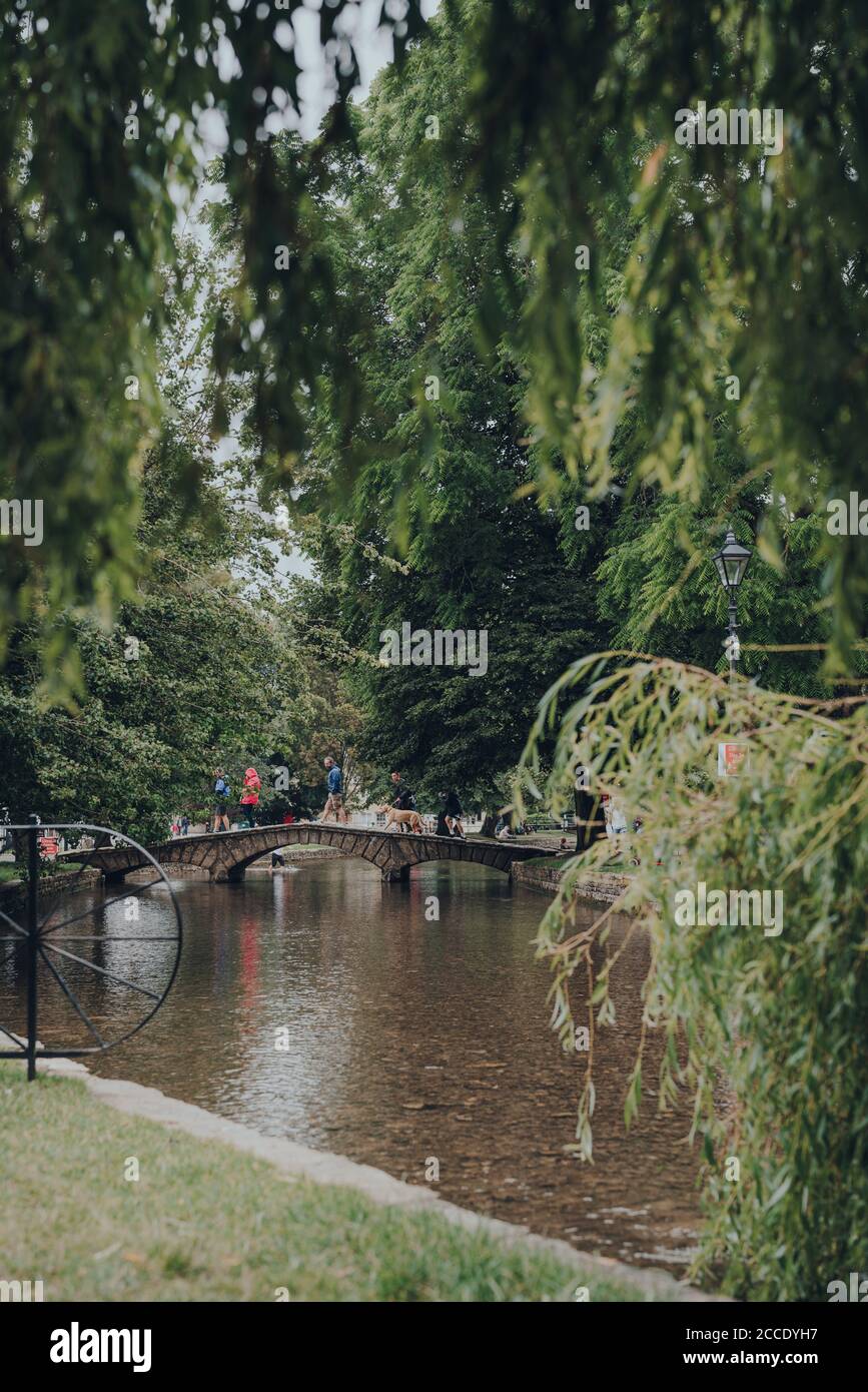 Bourton-on-the-Water, UK - 10 luglio 2020: Persone che camminano su un ponte di pietra sul fiume Windrush a Bourton-on-the-Water, un famoso villaggio in Foto Stock