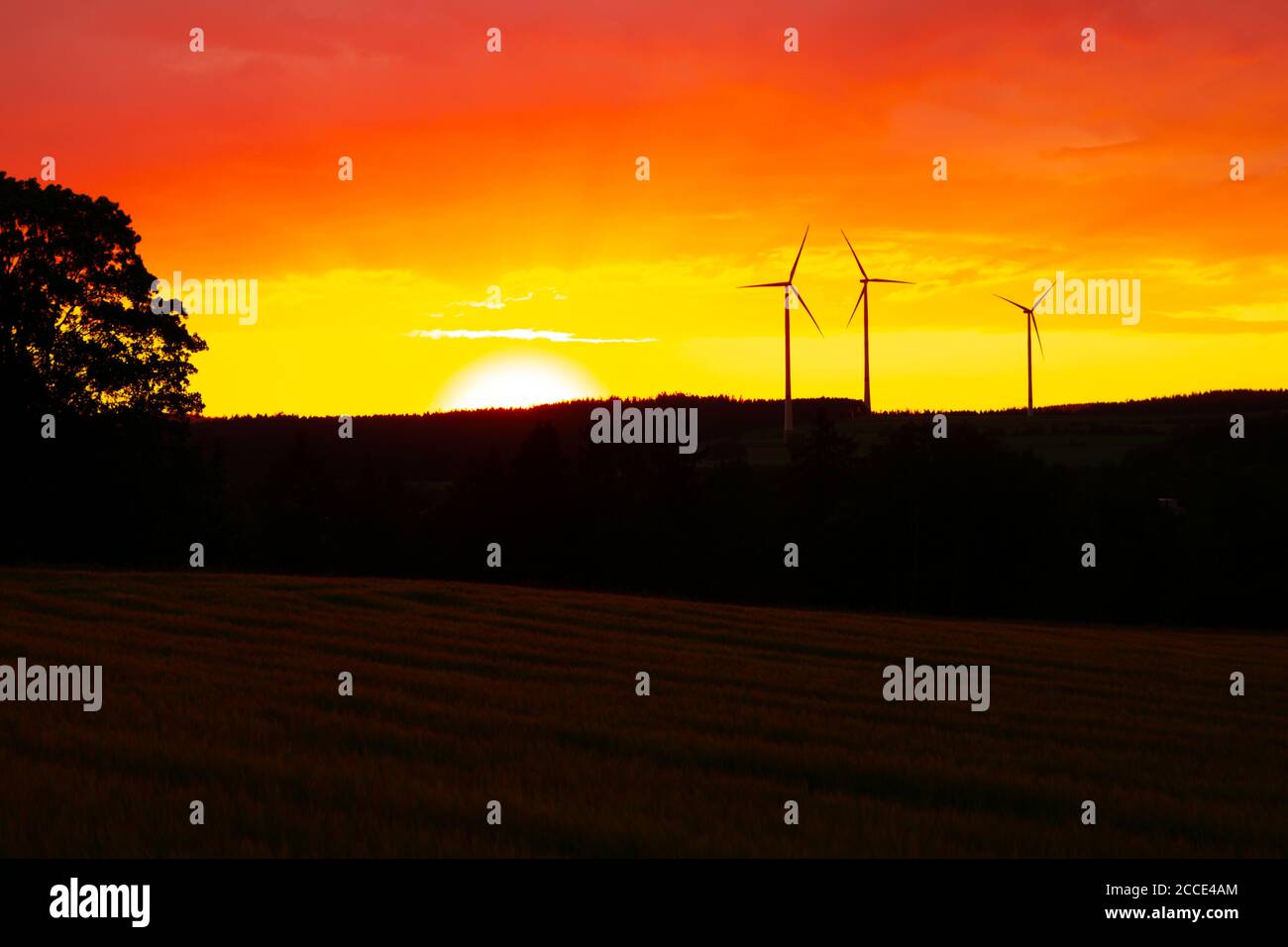 Orange Sky Sunset con le sagome delle turbine eoliche sullo sfondo Foto Stock