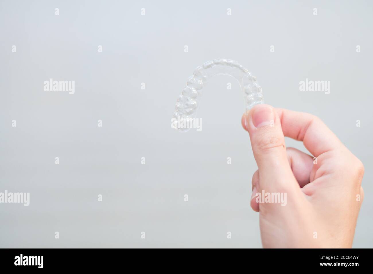 mano della donna che tiene un allineatore invisibile per la correzione dentale. ortodontico mobile Foto Stock