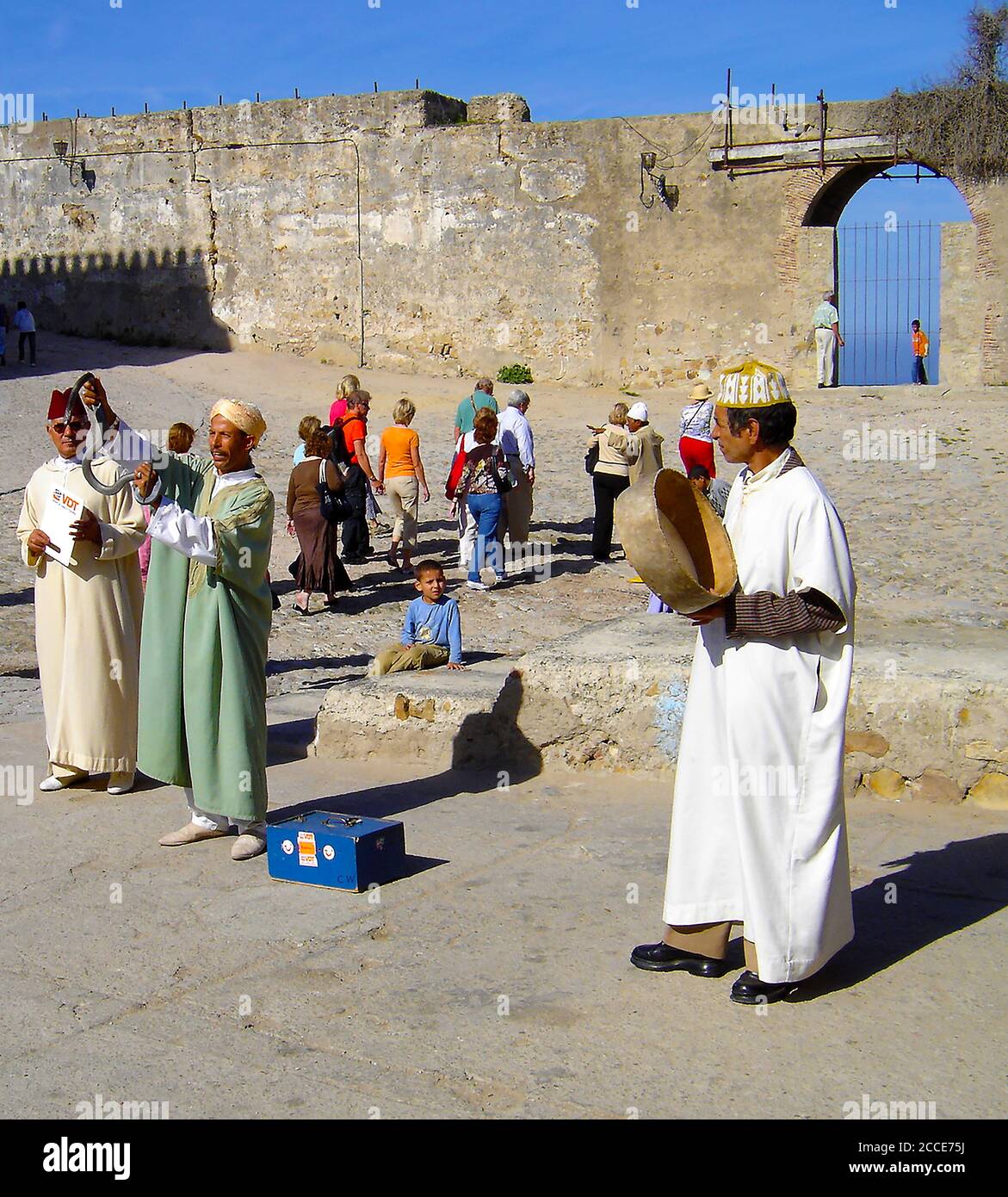 Ottobre 2005 - la Medina è un'area racchiusa da mura che contiene un labirinto di souk (luoghi di mercato), vicoli, negozi e artigiani che vendono i loro prodotti . L'acquisto comporta sempre contrattazioni. Questa fotografia mostra Snake Man si esibisce per i turisti che passano nella zona di Medina, esibendosi, fornendo un'opportunità fotografica e sperando che i turisti paghino per avere la loro fotografia scattata con il serpente. Dietro di lui si trovano le alte mura che circondano la medina. Foto Stock