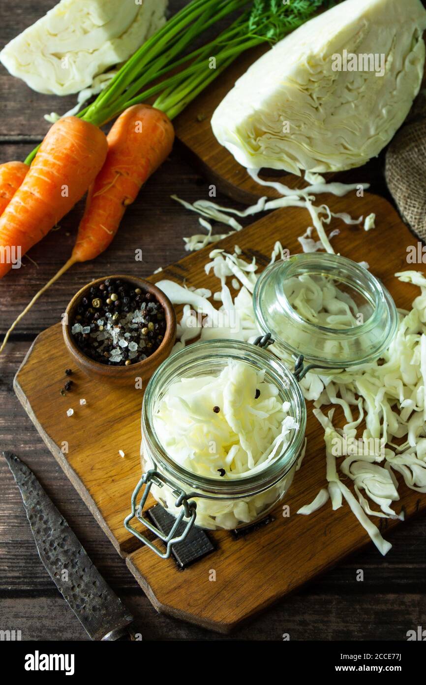 Sauerkraut preservando lo sfondo. Crauti fatti in casa con carote al pepe nero su rustico tavolo in legno. Cibo fermentato. Spazio di copia. Foto Stock