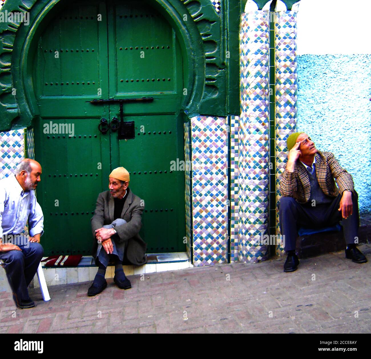 Ottobre 2005 - la Medina è un'area racchiusa da mura che contiene un labirinto di souk (luoghi di mercato), vicoli, negozi e artigiani che vendono i loro prodotti . L'acquisto comporta sempre contrattazioni. Questa fotografia mostra una strada posteriore dove gli anziani trovano un rifugio dal sole dove possono sedersi e rilassarsi o gossip con altri uomini e passanti. Foto Stock