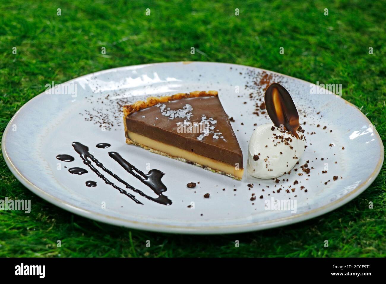 crostata di caramello salato con panna montata a sfondo verde Foto Stock