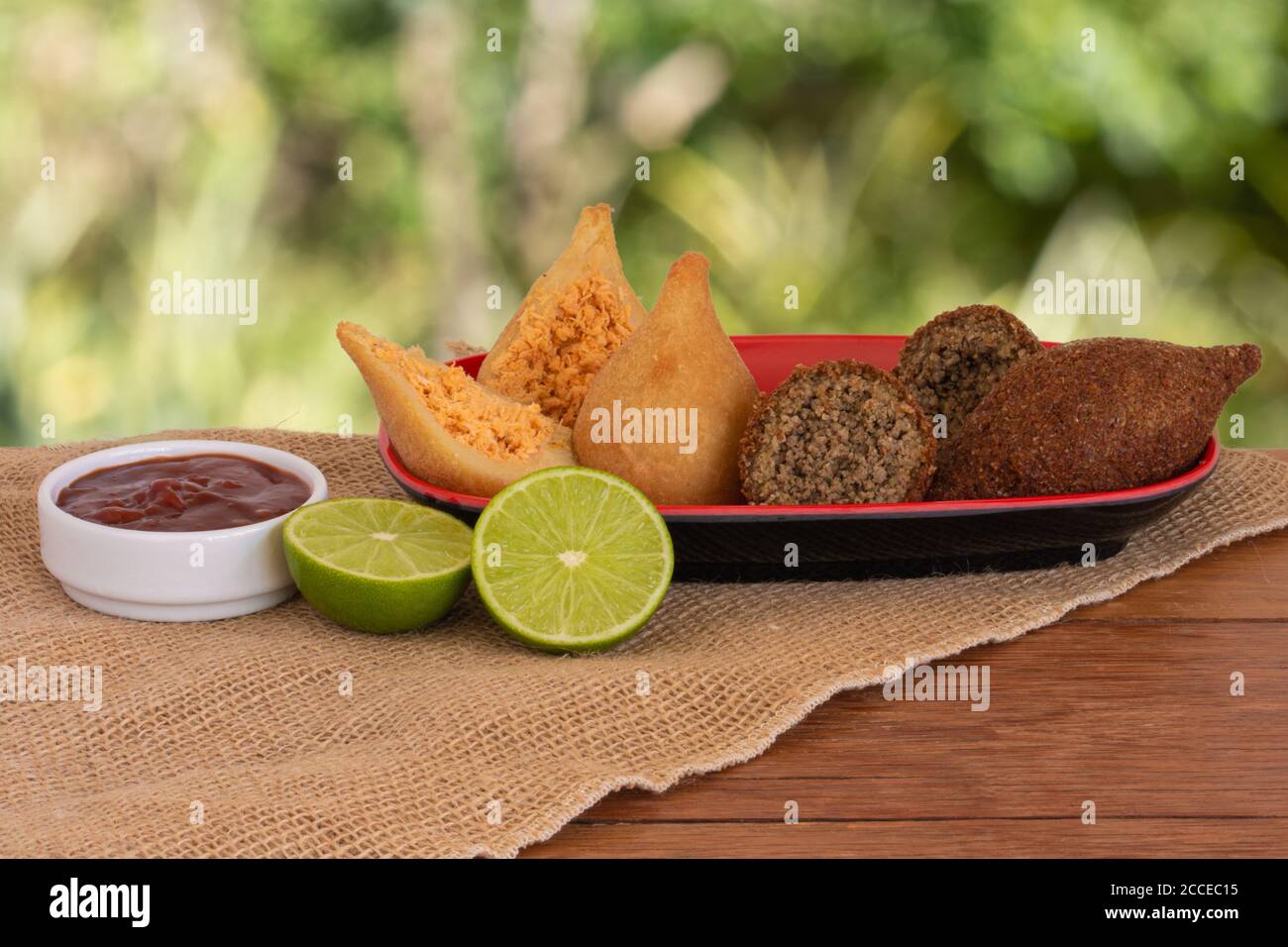 Coxinha e Kibe. Piatti tradizionali brasiliani fritti. Sfondo con verde sfocato. Copia spazio Foto Stock