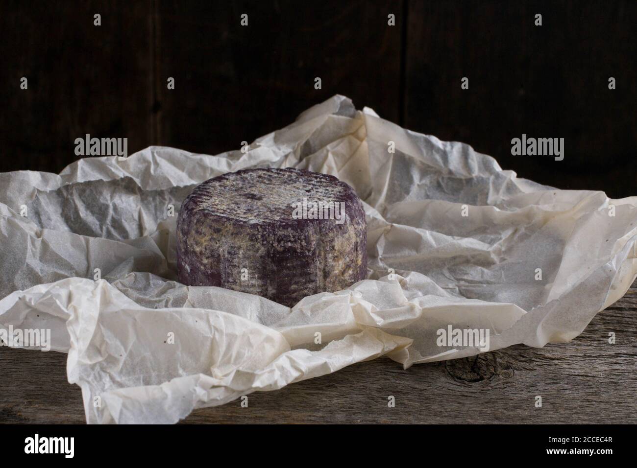 Primo piano di formaggio francese morbido con crosta viola carta Foto Stock