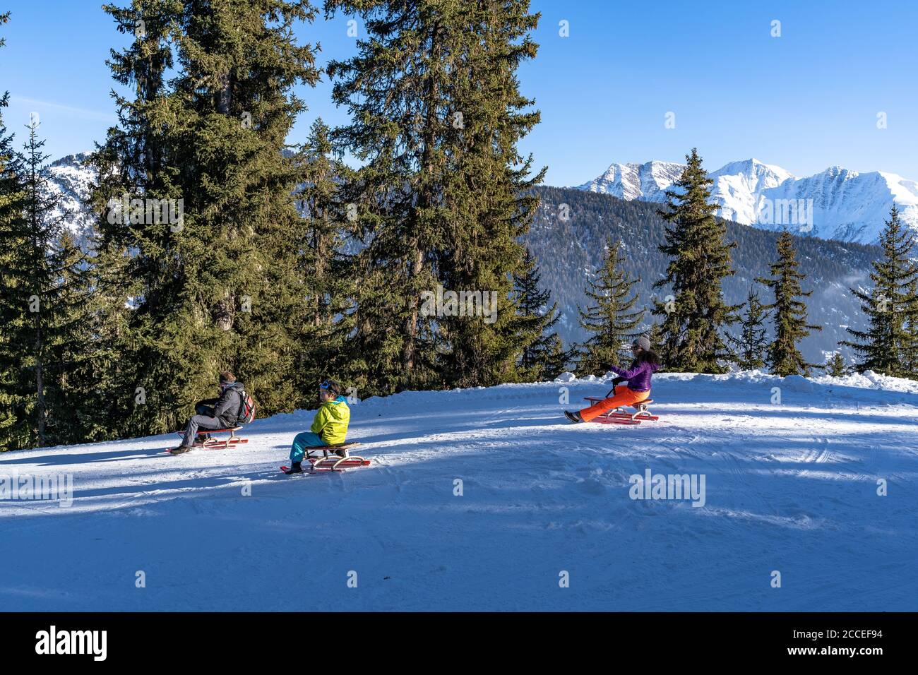 Europa, Svizzera, Vallese, Belalp, famiglia su una pista di slittino sullo sfondo di una montagna Foto Stock