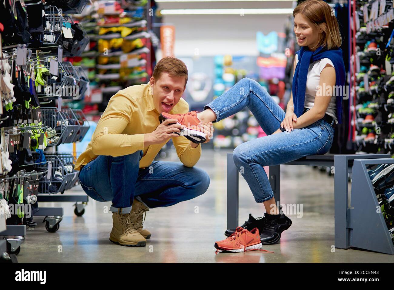 i giovani clienti caucasici sono venuti in negozio di abbigliamento  sportivo per fare l'acquisto, bel ragazzo e donna sono coinvolti in vari  sport, enorme. vasto assortimento di g Foto stock - Alamy