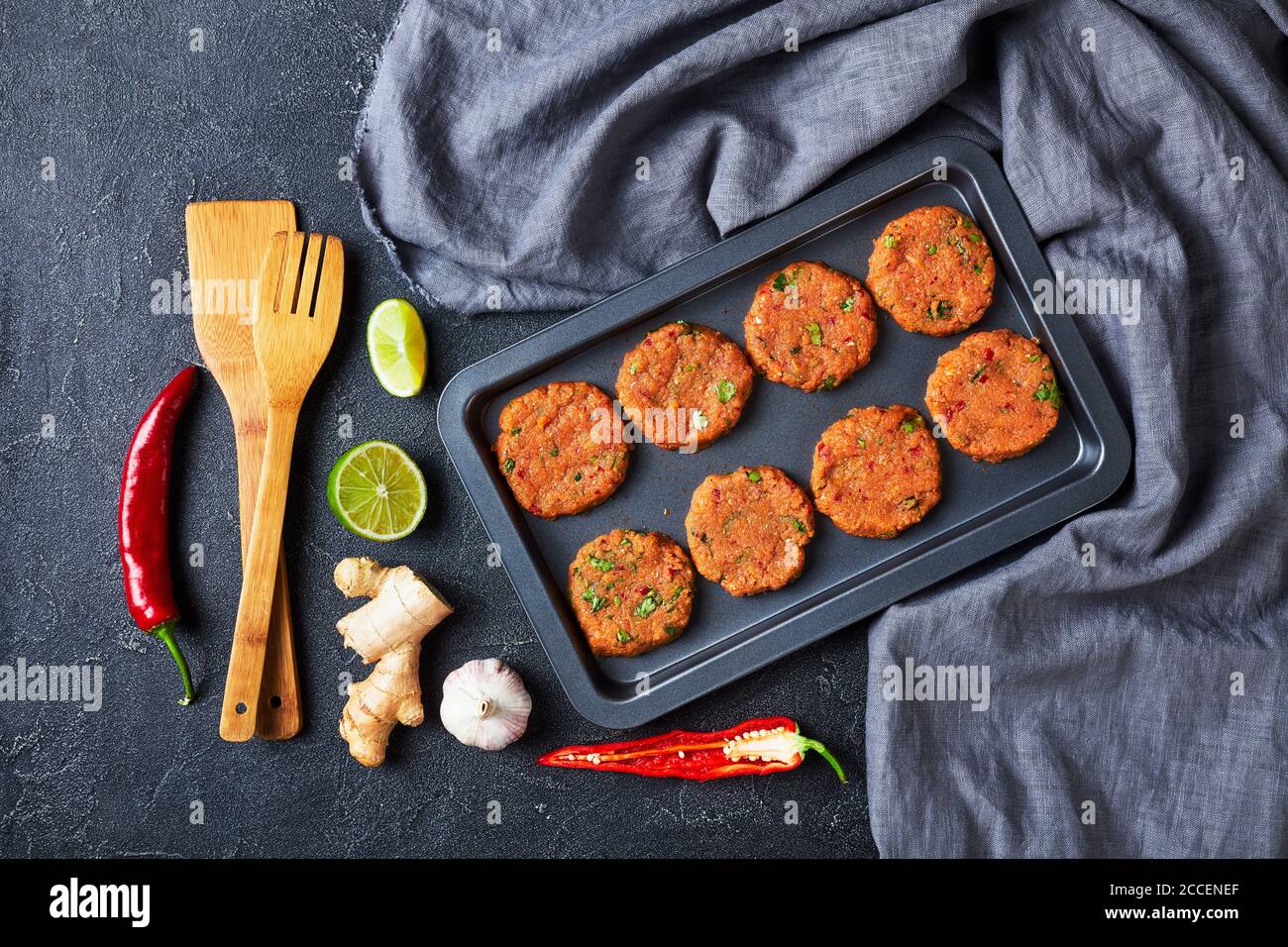 torte di pesce thailandesi crude preparate su una teglia da forno su un tavolo di cemento, vista panoramica dall'alto, piatto Foto Stock