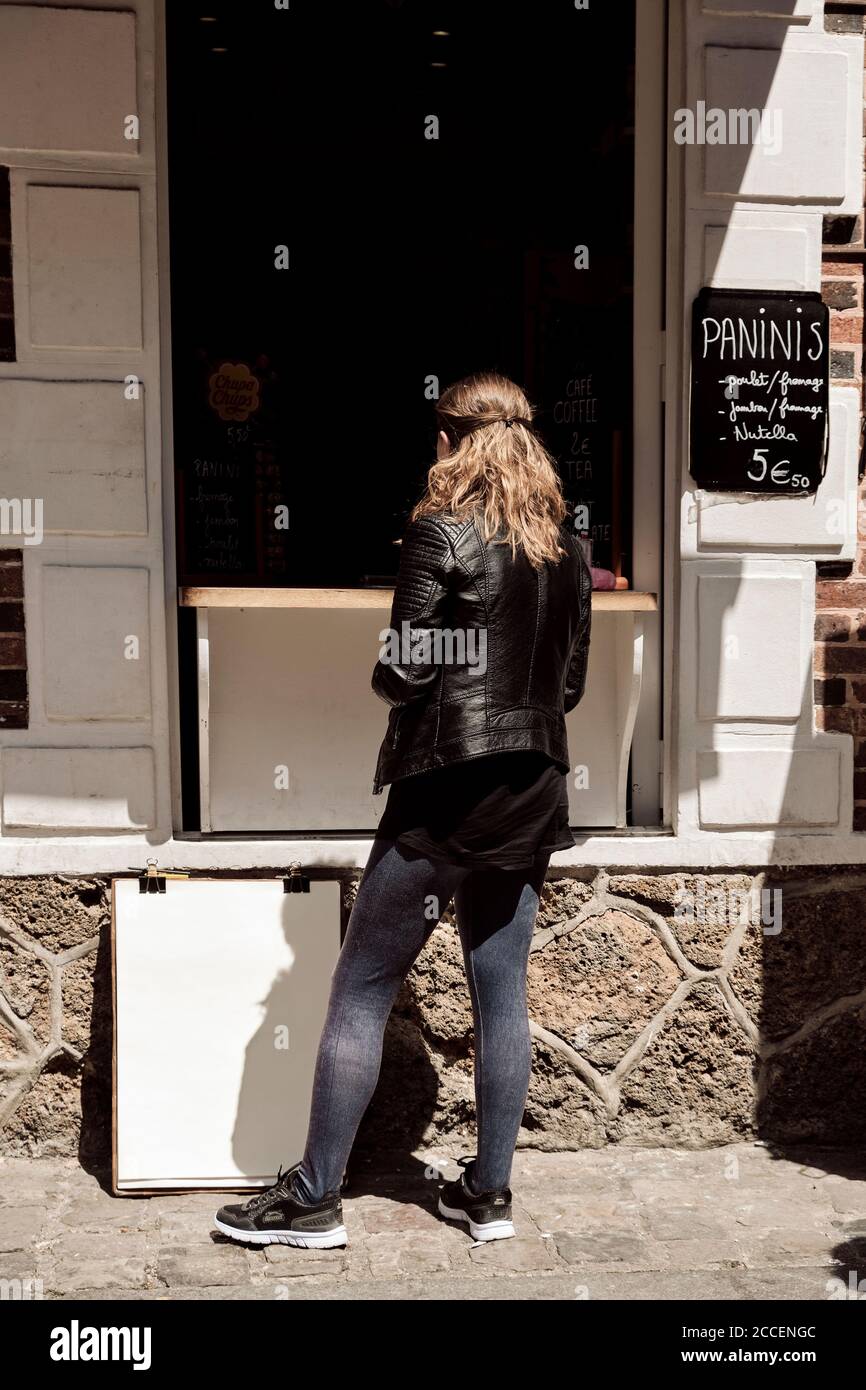 Europa, Francia, Parigi, Montmartre, Sacre Coeur, Young Woman sta per acquistare cibo di strada da andare, Foto Stock