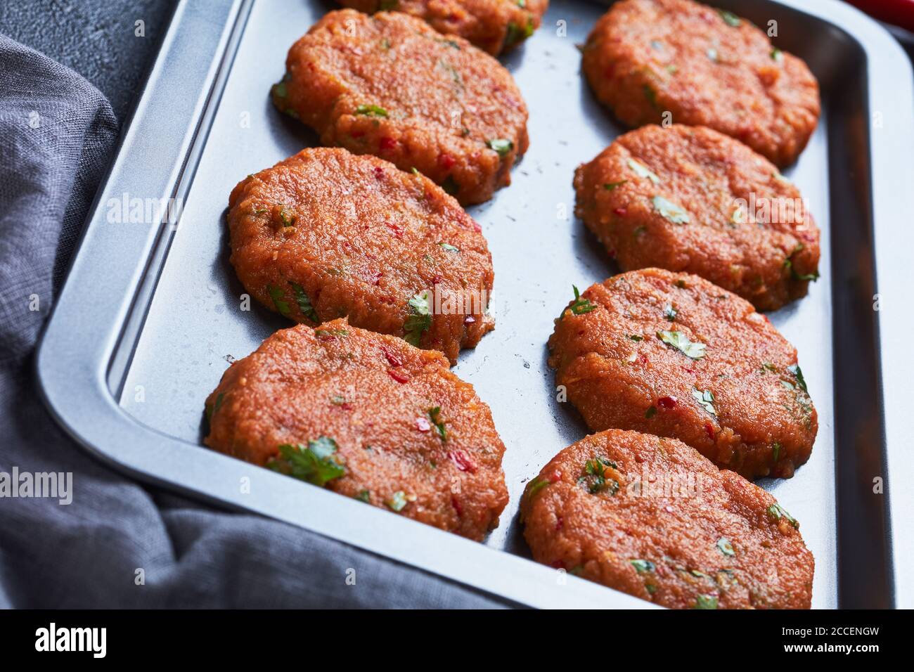 torte di pesce thailandesi crude preparate su una teglia da forno su un tavolo di cemento, vista dall'alto, primo piano Foto Stock