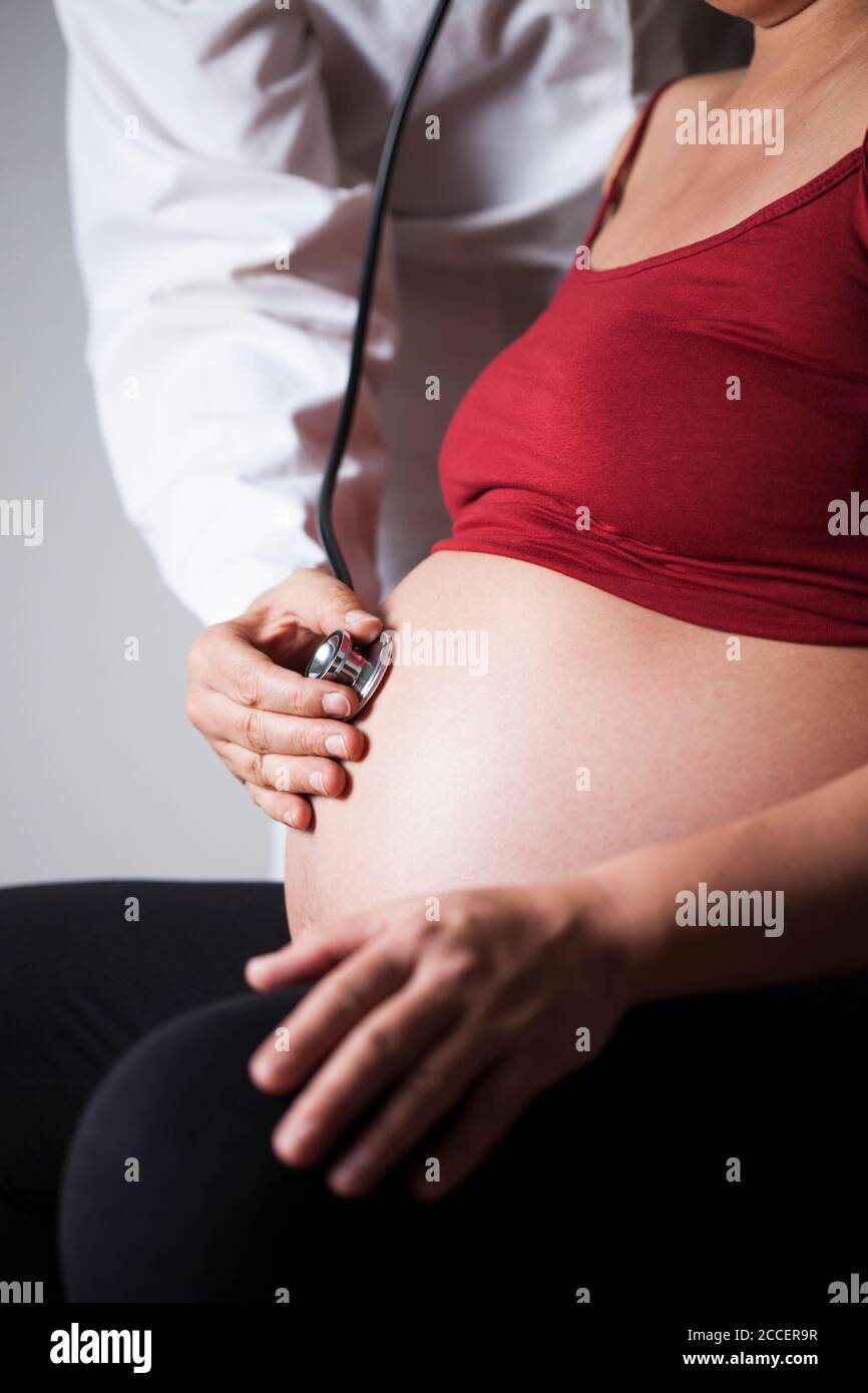 Medico che ascolta il battito cardiaco del feto Foto Stock